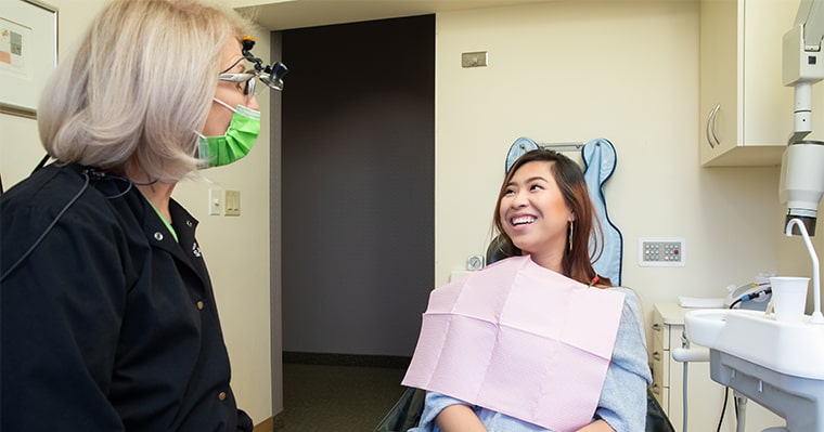 A woman sitting in dental chair for a family dentistry procedure