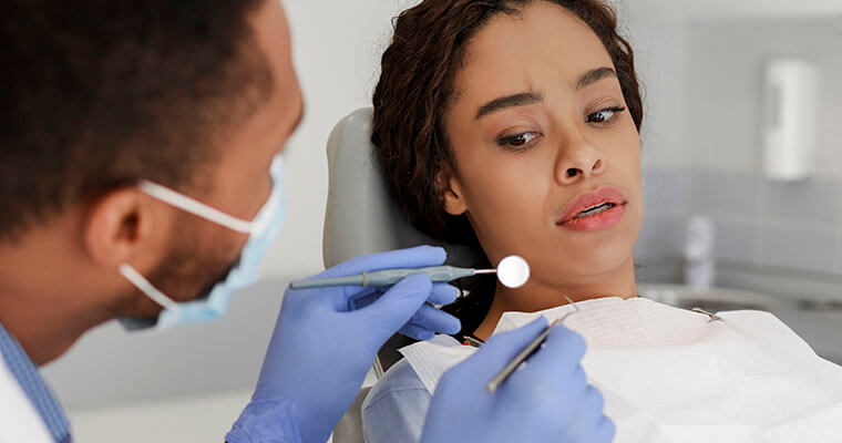 Patient in dental chair exhibits dental anxiety.