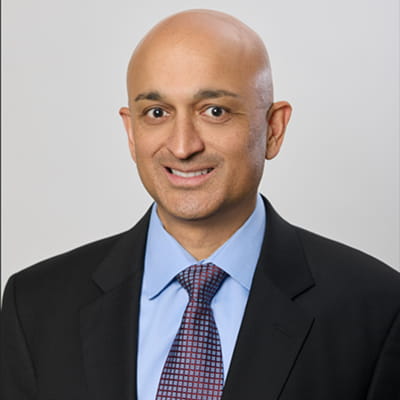 Headshot of one of our doctors, Dr. Bhide, smiling